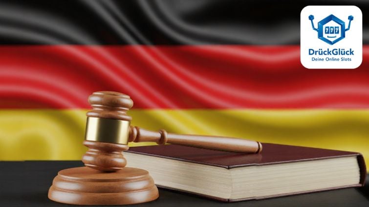 Richterhammer und Gesetzbuch vor der deutschen Flagge